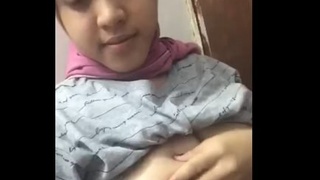 Young woman reveals her curves in a hijab tank top